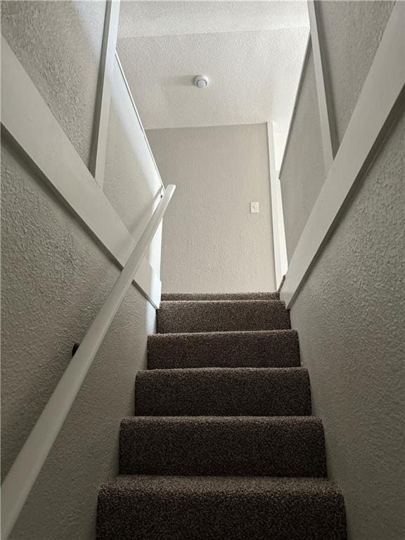 stairs with a textured ceiling