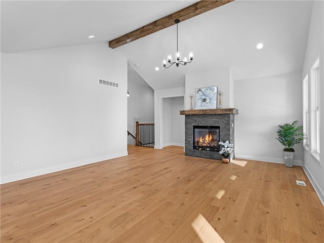 unfurnished living room with a stone fireplace, a chandelier, lofted ceiling with beams, and light wood-type flooring