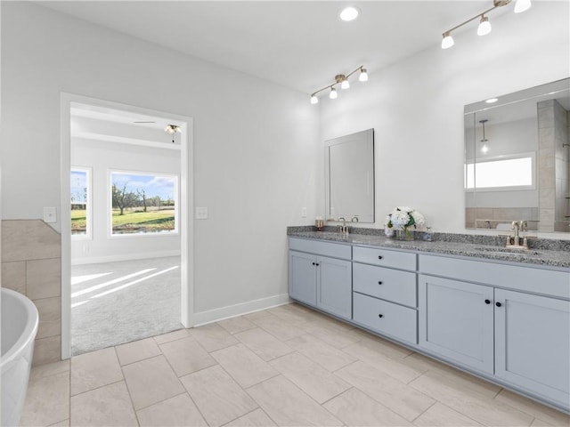 bathroom featuring tile patterned floors, a tub, ceiling fan, and vanity