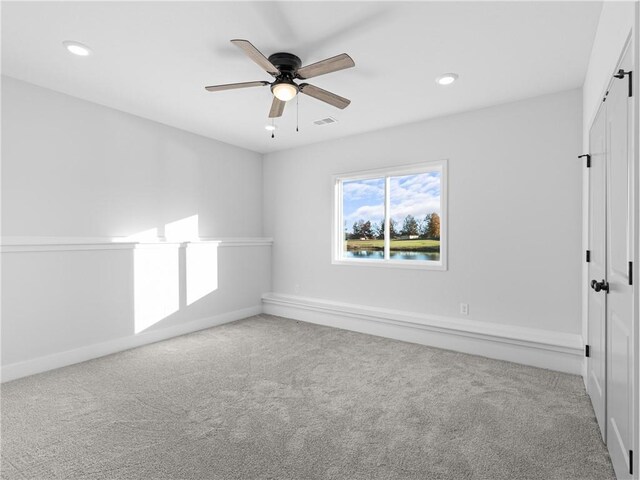 unfurnished room featuring light carpet and ceiling fan