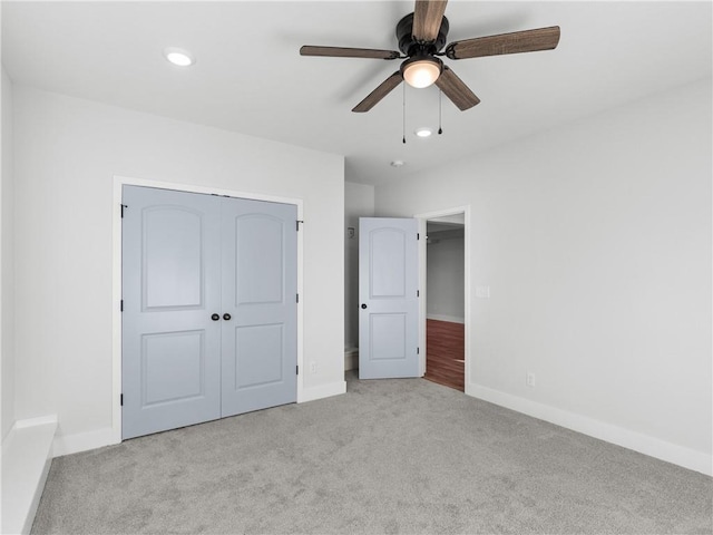 unfurnished bedroom with ceiling fan, light colored carpet, and a closet