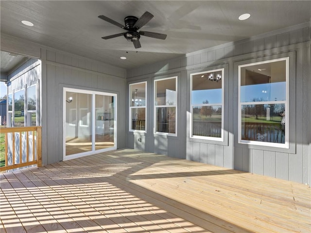 unfurnished sunroom featuring ceiling fan