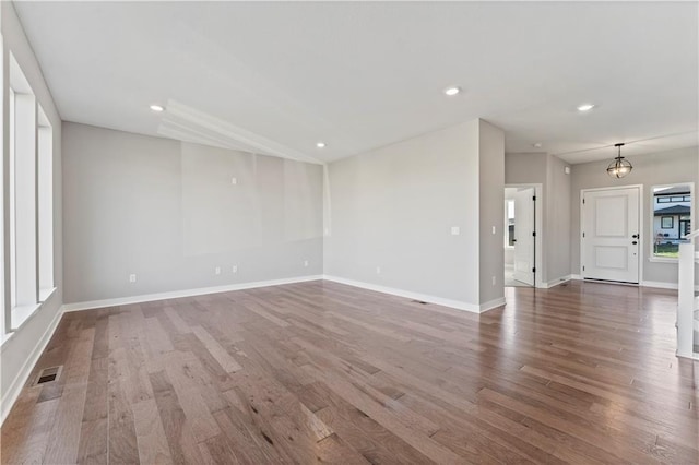 unfurnished room with baseboards, visible vents, wood finished floors, and recessed lighting