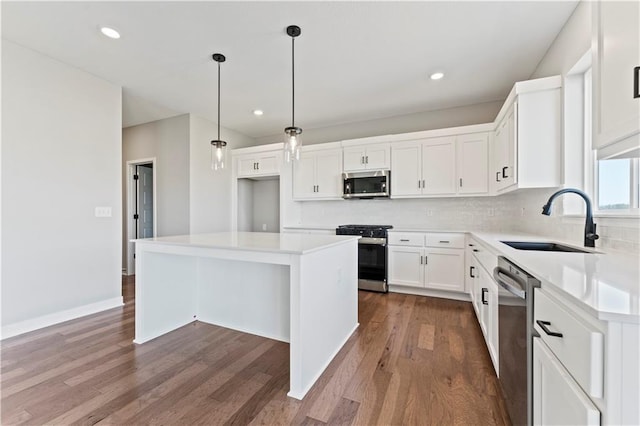 kitchen featuring stainless steel appliances, backsplash, dark wood-style floors, and a sink