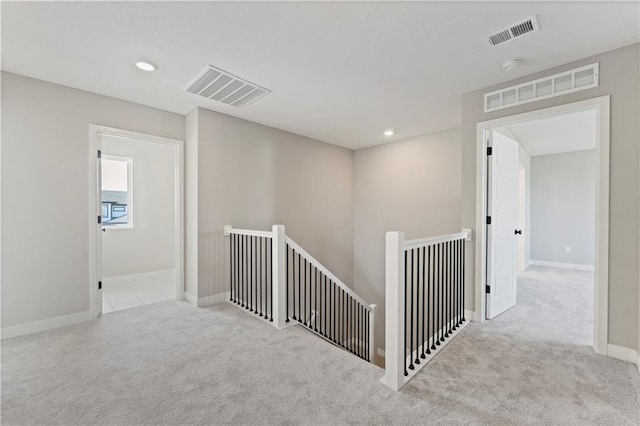 interior space with an upstairs landing, visible vents, and carpet