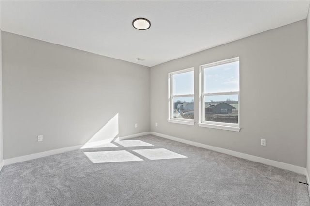 carpeted empty room with visible vents and baseboards