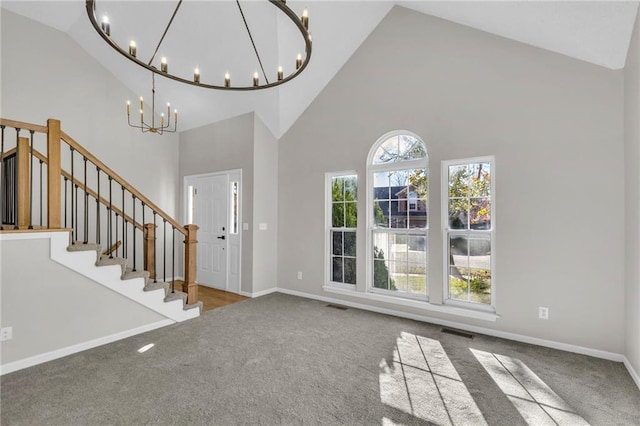 entrance foyer with carpet, high vaulted ceiling, and a chandelier