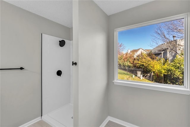 bathroom with a textured ceiling and walk in shower