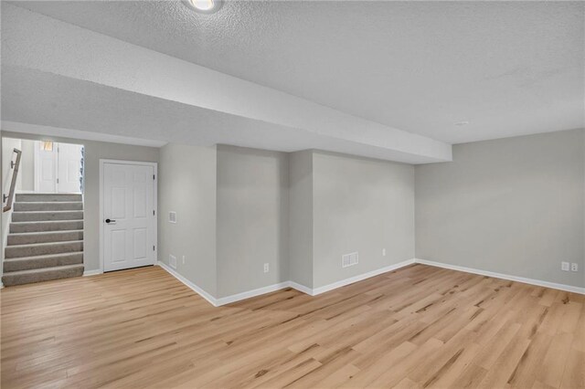 basement with a textured ceiling and light wood-type flooring