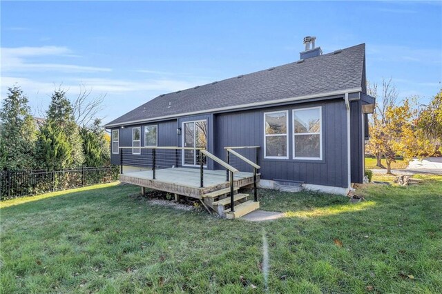 rear view of house featuring a deck and a yard