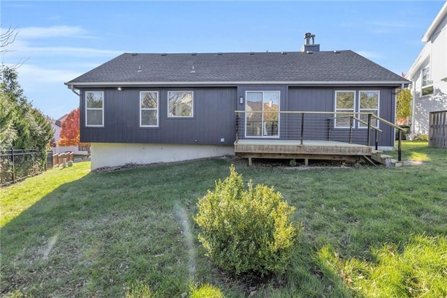 back of property with a wooden deck and a lawn