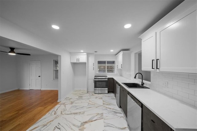 kitchen with recessed lighting, stainless steel appliances, a sink, light countertops, and decorative backsplash