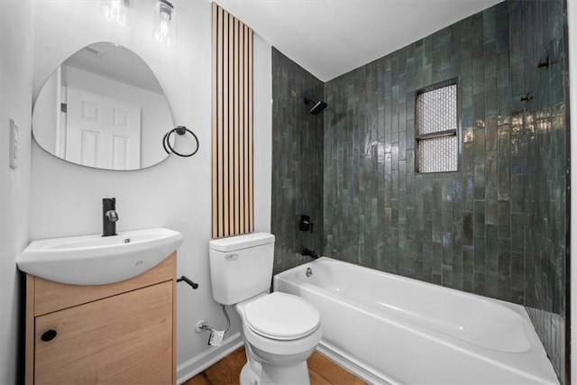 bathroom with baseboards, toilet, wood finished floors,  shower combination, and vanity