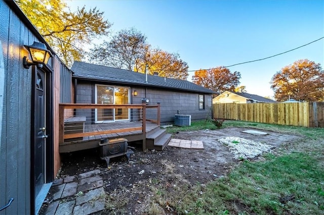 rear view of property featuring central AC, fence, and a wooden deck