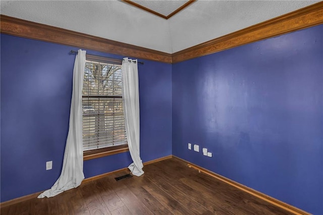 empty room with visible vents, baseboards, and wood finished floors