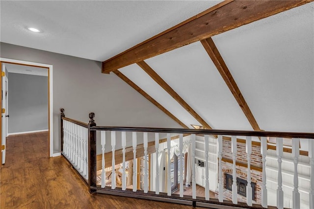 hallway featuring vaulted ceiling with beams, baseboards, and wood finished floors