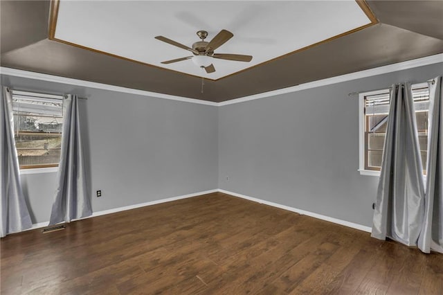 empty room featuring visible vents, ornamental molding, a ceiling fan, wood finished floors, and baseboards