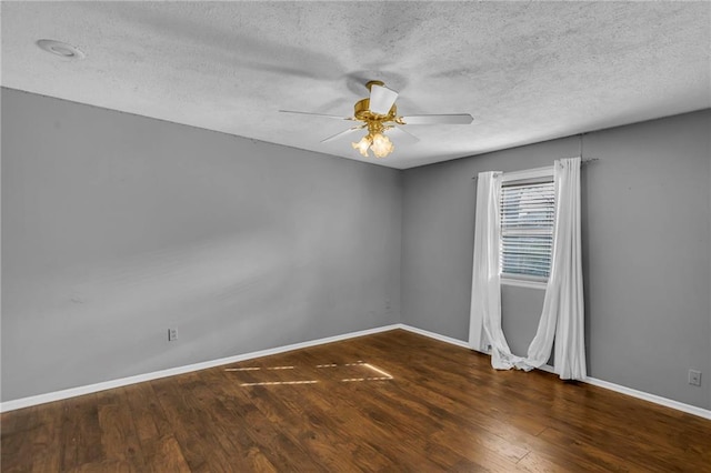 empty room featuring ceiling fan, a textured ceiling, baseboards, and wood finished floors