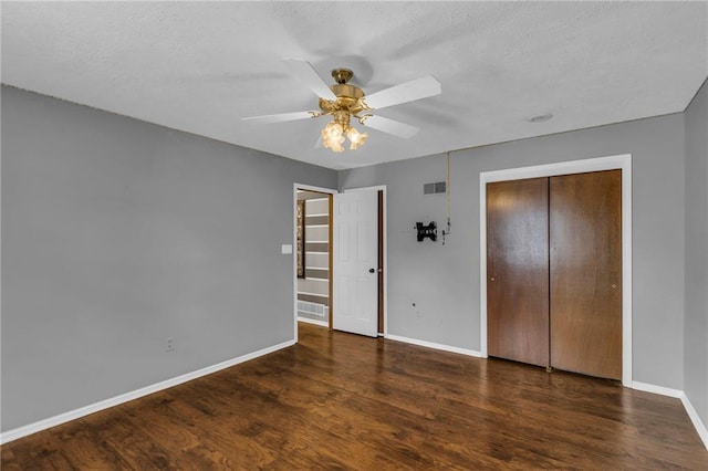 unfurnished bedroom featuring visible vents, ceiling fan, baseboards, and wood finished floors