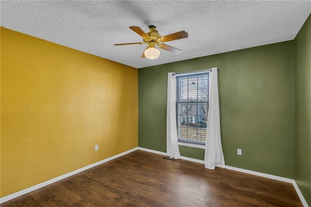 spare room with a ceiling fan, a textured ceiling, baseboards, and wood finished floors