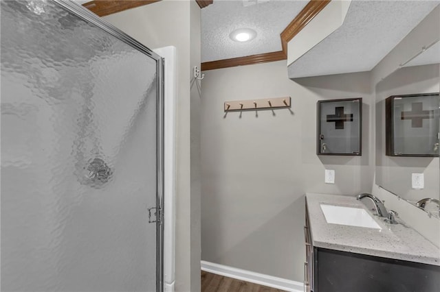 full bathroom featuring baseboards, wood finished floors, a textured ceiling, vanity, and a shower stall