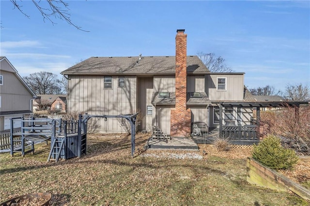 back of house featuring a shingled roof, a patio, and a chimney