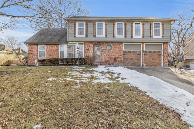 colonial-style house featuring brick siding, an attached garage, fence, and aphalt driveway