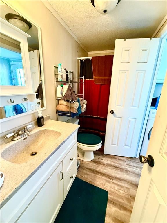 bathroom with toilet, a textured ceiling, ornamental molding, vanity, and hardwood / wood-style flooring