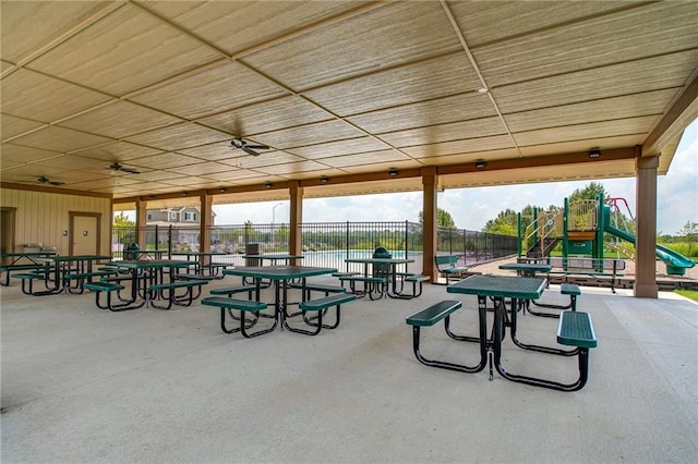 view of home's community with a playground, a patio area, and a water view