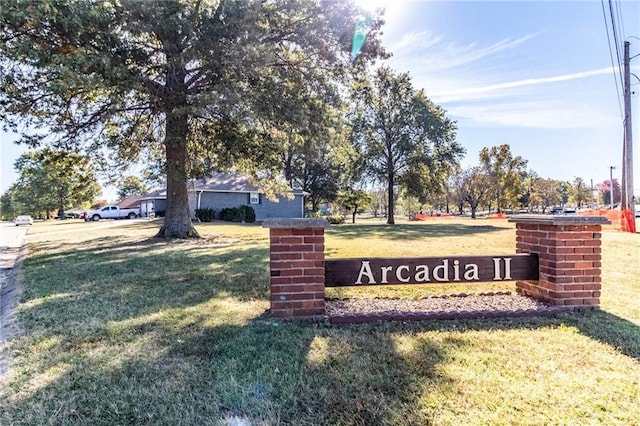 community sign featuring a lawn