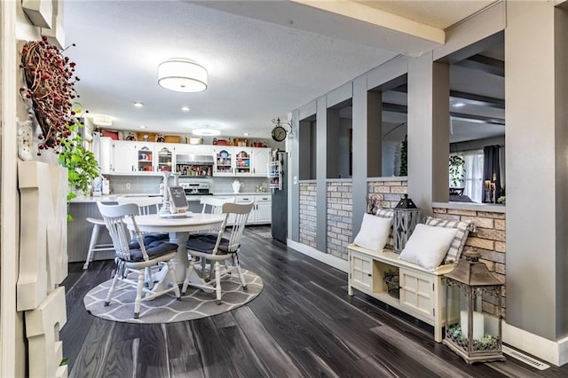 dining room featuring a textured ceiling and dark wood-type flooring