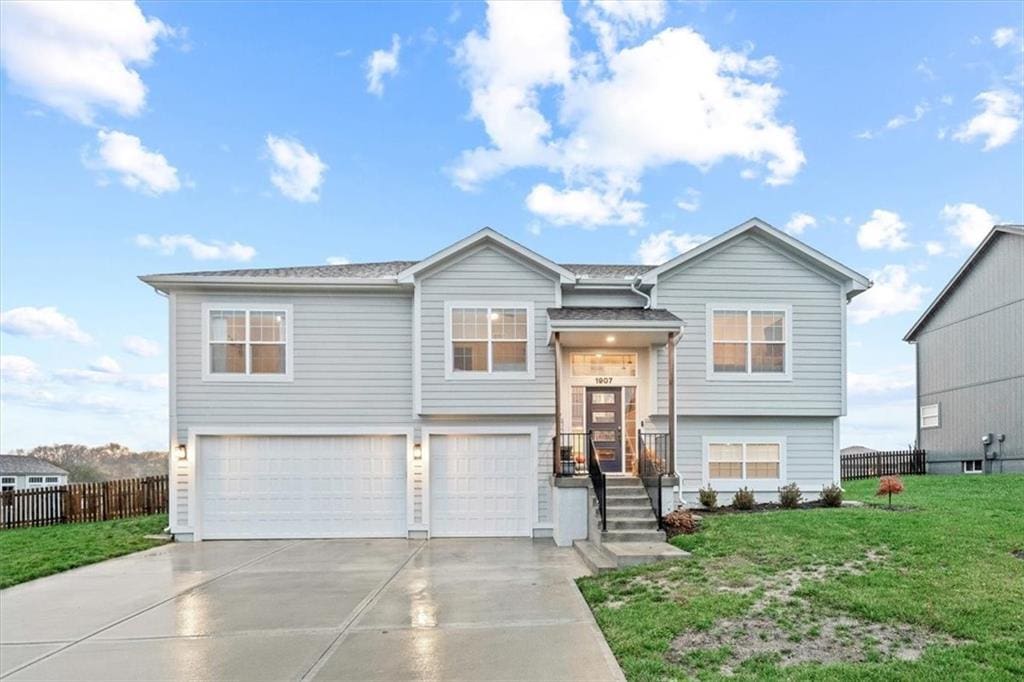 raised ranch with a garage and a front lawn