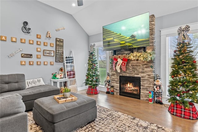 living room with hardwood / wood-style flooring, plenty of natural light, a fireplace, and vaulted ceiling