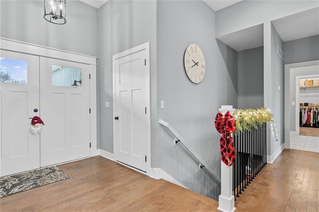 foyer entrance featuring wood-type flooring and an inviting chandelier