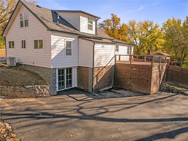 rear view of house with central AC and a deck