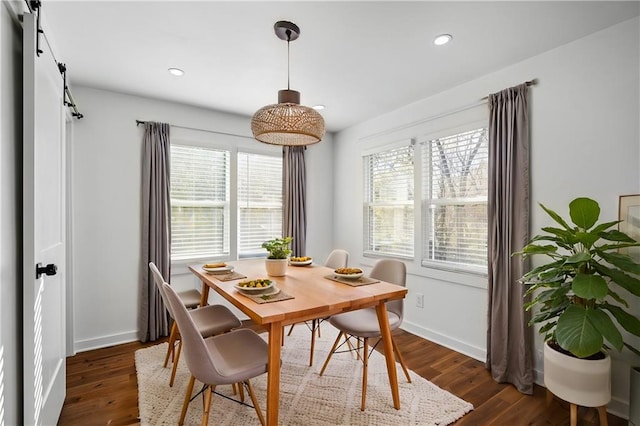 dining room featuring a barn door and dark hardwood / wood-style floors