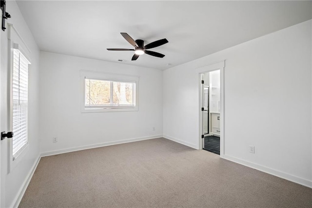 carpeted spare room featuring a barn door and ceiling fan