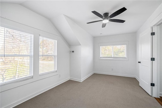 additional living space featuring a wealth of natural light, light colored carpet, and lofted ceiling