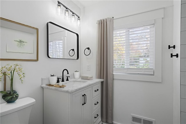 bathroom featuring vanity and toilet