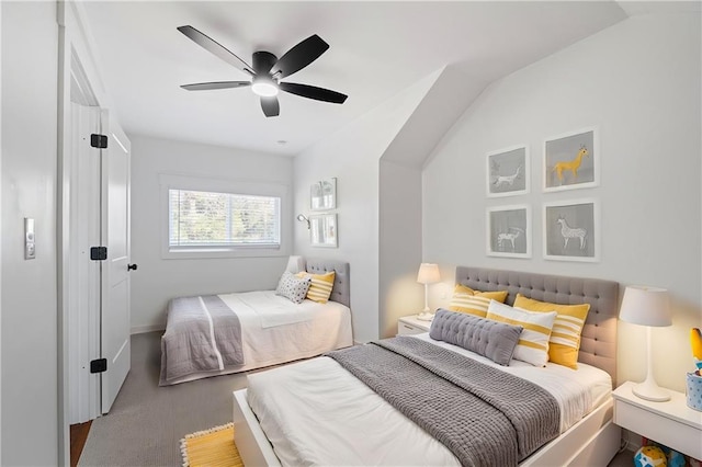 carpeted bedroom with ceiling fan and vaulted ceiling