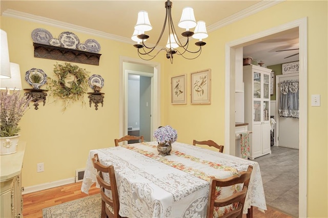 dining room with ceiling fan with notable chandelier, light wood-type flooring, and crown molding