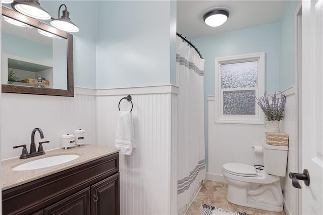 bathroom with a shower with curtain, tile patterned flooring, vanity, and toilet