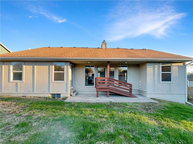 rear view of house featuring a patio and a lawn