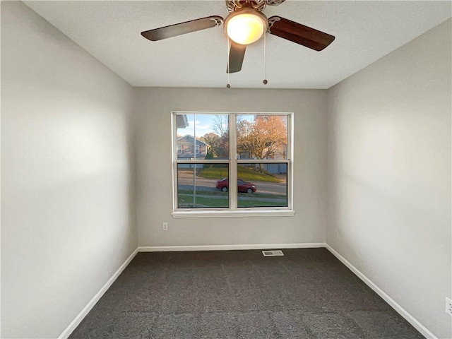 carpeted spare room featuring ceiling fan