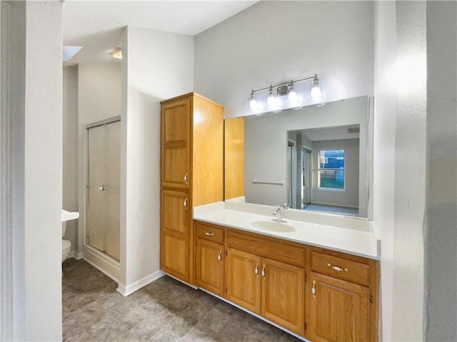 bathroom featuring a shower with door, vanity, and toilet