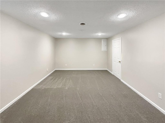 carpeted empty room featuring a textured ceiling