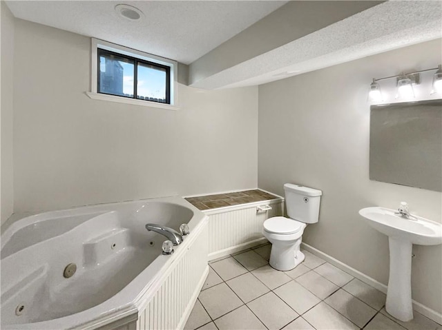 bathroom with tile patterned floors, sink, toilet, a textured ceiling, and a tub