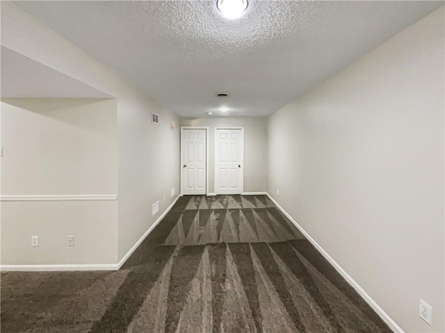 hall with dark hardwood / wood-style flooring and a textured ceiling