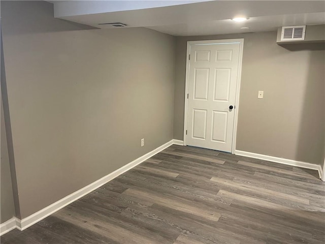 spare room with visible vents, baseboards, and dark wood-style floors