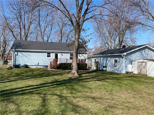 exterior space with a storage unit, an outbuilding, a deck, a front yard, and a shingled roof